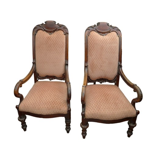 500 - A pair of mid Victorian mahogany open arm chairs, with carved top rail, padded back and seat, uphols... 