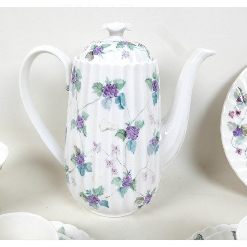 81 - A modern hand painted bone china tea set, decorated with purple flowers and leaves, each signed 'Han... 