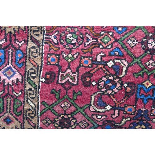 555 - A Persian hand knotted runner, red ground, floral decoration, 365 by 100cm.