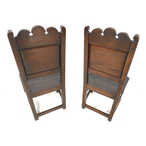 526 - A pair of oak hall chair with carved backs. 47 by 40 by 110cm. (2)