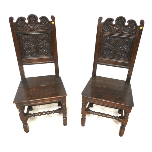 526 - A pair of oak hall chair with carved backs. 47 by 40 by 110cm. (2)