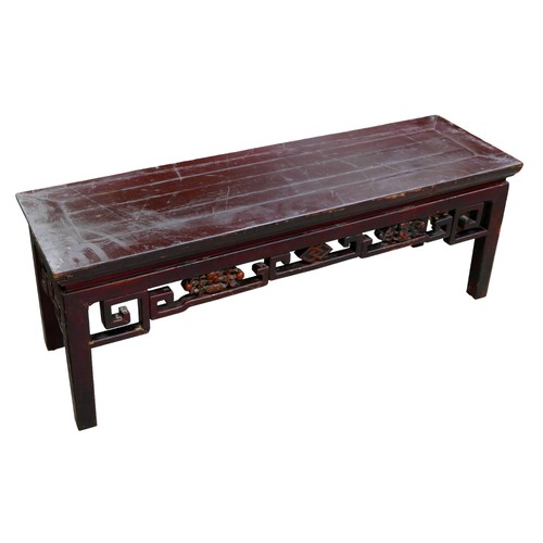 533 - A Chinese hardwood low opium side table with carved frieze, 113 by 34 by 40cm.