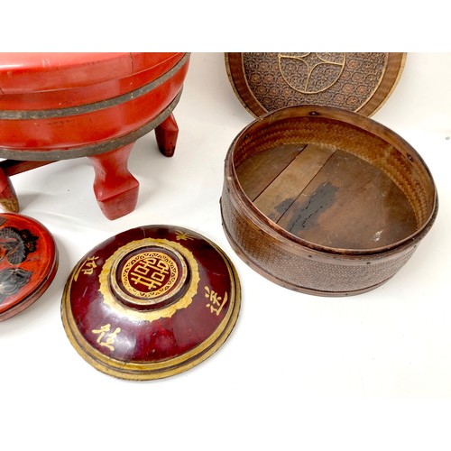 15 - A collection of eight Chinese wooden and rattan bowls, the largest painted red and raised on four le... 