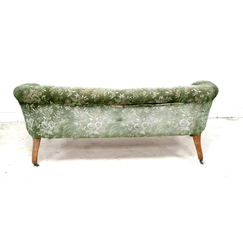 543 - A Victorian two seater settee, with floral carved scroll arms, upholstered in green and cream foliat... 