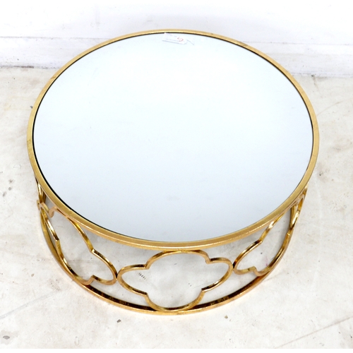 510 - A modern mirror topped coffee table, the circular surface on a brass effect open frame base formed o... 