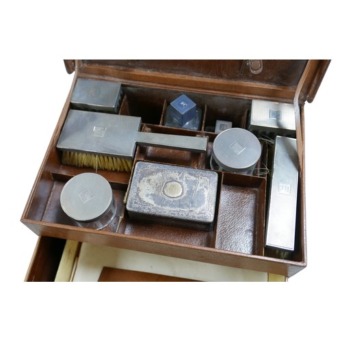 319 - A 1930's pigskin leather travel box with six silver top bottles, a mirror and two brushes hallmarked... 