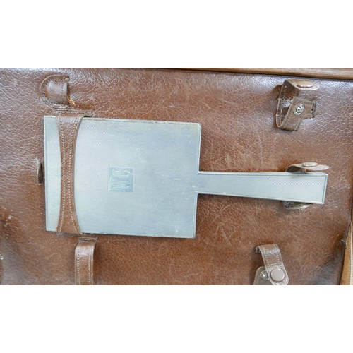 319 - A 1930's pigskin leather travel box with six silver top bottles, a mirror and two brushes hallmarked... 