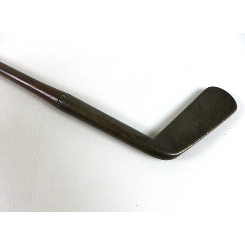 142 - An Edwardian hickory shafted golf club, putter, with brass head and leather grip, face 9 by 3cm, sha... 