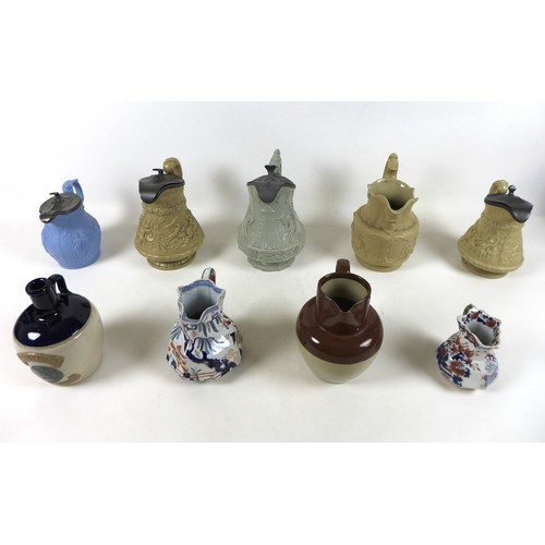 88 - A collection of five relief moulded stoneware jugs including monkeys playing cards, three other jugs... 