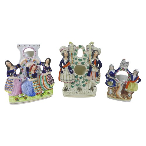 97 - A collection of thirteen Staffordshire figures and groups, including three watch holders, together w... 