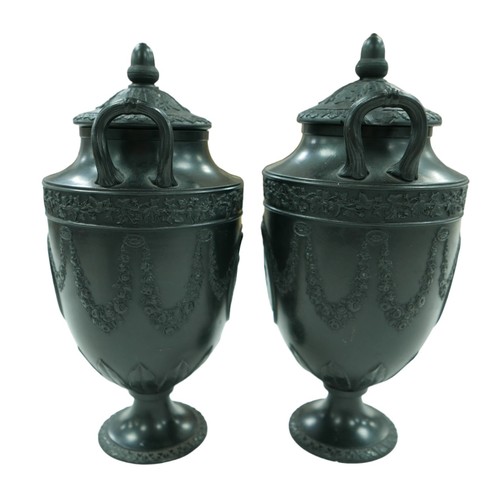 111 - A pair of mid 19th century Wedgwood black basalt twin-handled urns and covers, each decorated in Neo... 