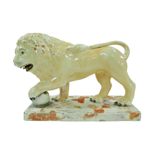 99 - A 18th century or later Staffordshire figurine modelled as a Medici lion, with for paw resting upon ... 