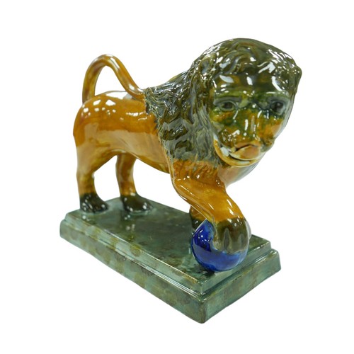 91 - A 18th century or later Staffordshire figurine modelled as a Medici lion, with for paw resting upon ... 