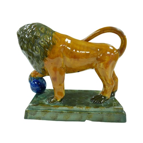 91 - A 18th century or later Staffordshire figurine modelled as a Medici lion, with for paw resting upon ... 