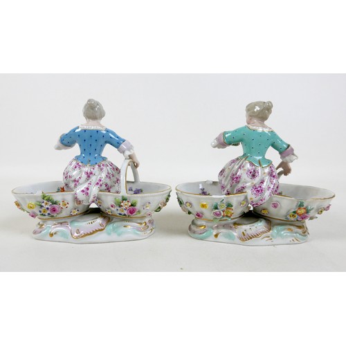 106 - A group of four 19th century Meissen salts, modelled as figures in 18th century attire sitting on tw... 