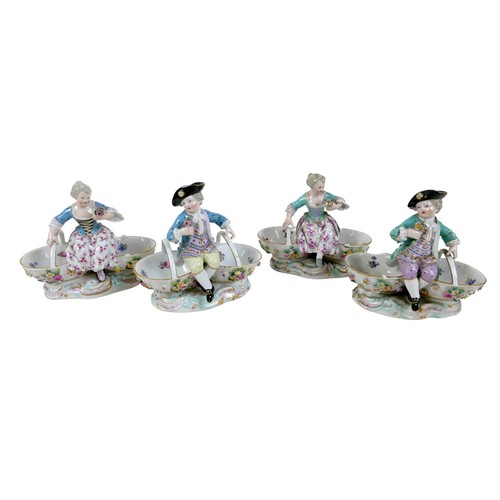 106 - A group of four 19th century Meissen salts, modelled as figures in 18th century attire sitting on tw... 