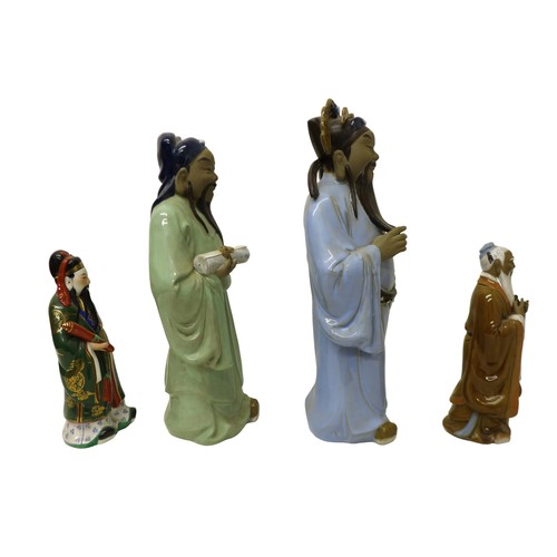 10 - A group of four modern Chinese pottery figures, modelled as a man holding a scroll in pale blue robe... 