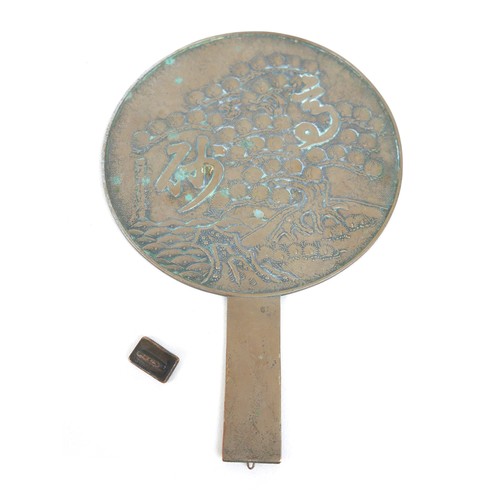 13 - A Chinese bronze hand mirror and a drug weight, mirror 20cm by 30cm, weight 20.5 grammes.