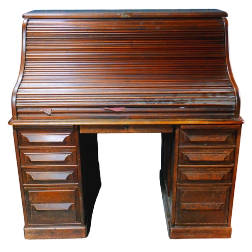 546 - An Edwardian oak roll top desk by Cutler, with fitted interior including pen and ink well holder, pi... 