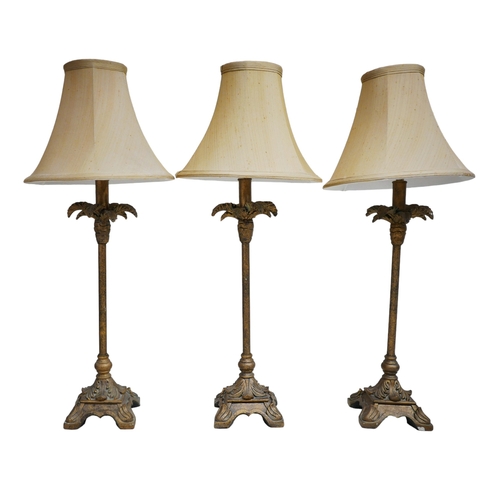 349 - A group of three table lamps with palm tree bases, cream shades, each 27 by 70 cm high. (3)