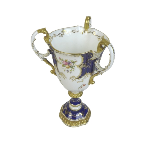 86 - An Edwardian Coalport porcelain goblet-vase, shape 144, modelled with three handles, flared rim, on ... 