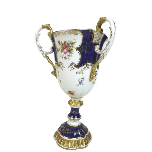 86 - An Edwardian Coalport porcelain goblet-vase, shape 144, modelled with three handles, flared rim, on ... 