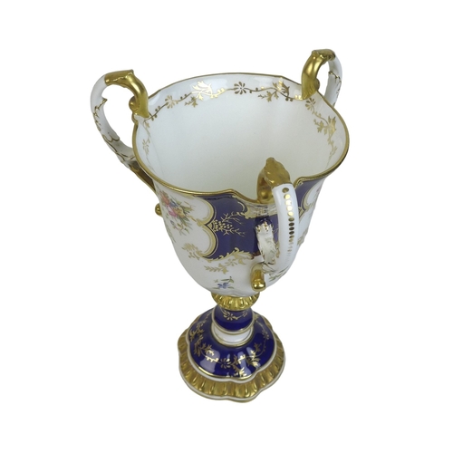 86 - An Edwardian Coalport porcelain goblet-vase, shape 144, modelled with three handles, flared rim, on ... 