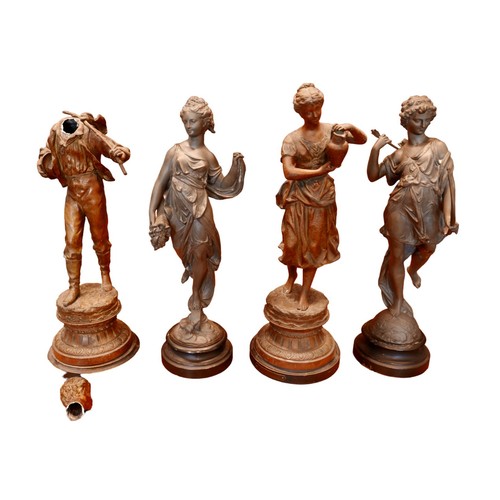 334 - Two pairs of spelter sculptures, modelled as standing figures, on circular bases, 44 and 46cm high. ... 