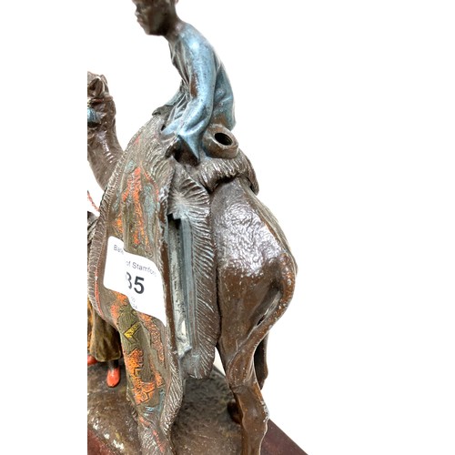 335 - A cast metal sculpture, in the style of Franz Bergmann, modelled as a Persian rug seller, with camel... 