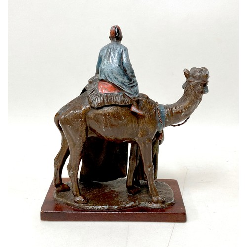 335 - A cast metal sculpture, in the style of Franz Bergmann, modelled as a Persian rug seller, with camel... 