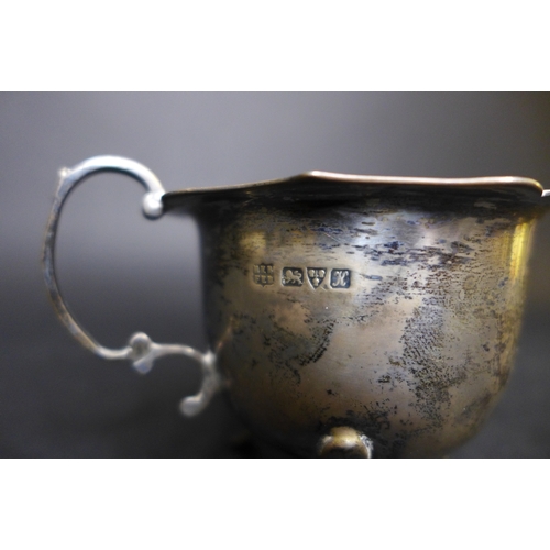 72 - An Edwardian silver three piece tea set, comprising milk jug, teapot with ebonized wooden handle and... 