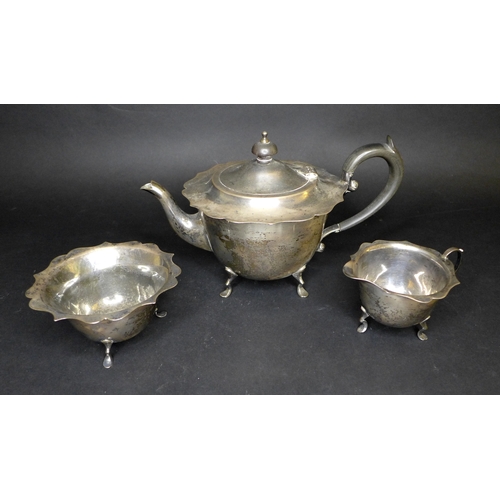 72 - An Edwardian silver three piece tea set, comprising milk jug, teapot with ebonized wooden handle and... 