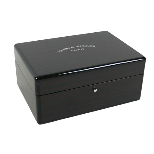 120 - An exotic wood watch box, branded for 'Franck Muller, Geneve', with fitted interior and chromed meta... 