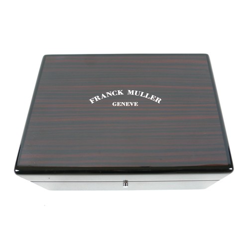 120 - An exotic wood watch box, branded for 'Franck Muller, Geneve', with fitted interior and chromed meta... 