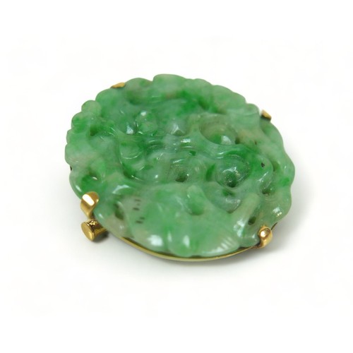 193 - A carved green jade brooch in an Egyptian yellow gold 625 setting, 3cm diameter, 8.7 grams.