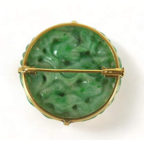 193 - A carved green jade brooch in an Egyptian yellow gold 625 setting, 3cm diameter, 8.7 grams.