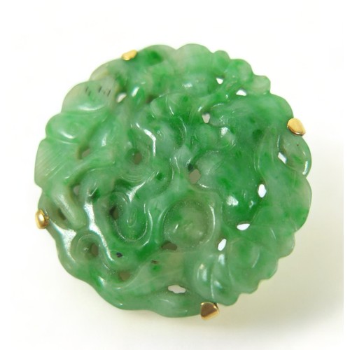 193 - A carved green jade brooch in an Egyptian yellow gold 625 setting, 3cm diameter, 8.7 grams.