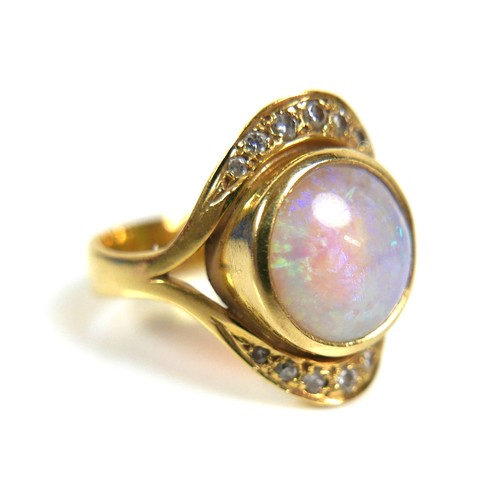 323 - An 18ct gold, opal and diamond ring, centered by a round cabochon opal, 10.5mm, pave set above and b... 