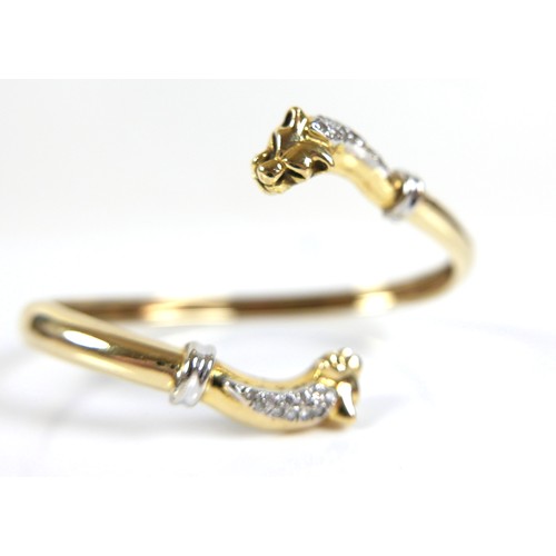 322 - A yellow gold open torc style bangle, formed with a panther's head at each end, set with small diamo... 