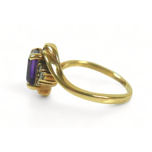 175 - A yellow metal dress ring, set with a rectangular faceted cut purple stone, 7 by 5 by 3mm, flanked b... 