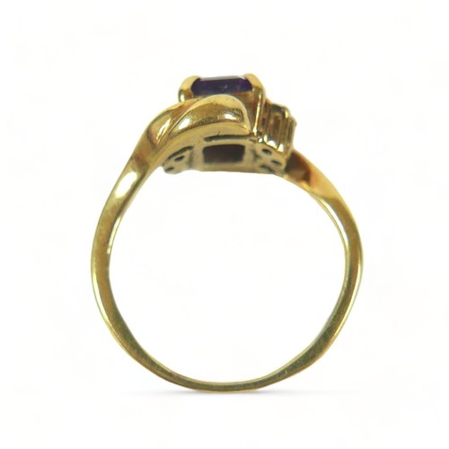 175 - A yellow metal dress ring, set with a rectangular faceted cut purple stone, 7 by 5 by 3mm, flanked b... 