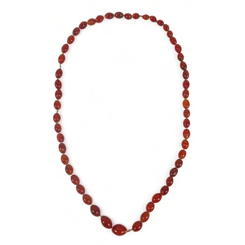 301 - An amber necklace with oval graduated beads, reddish amber colour, 80cms long plus 21 large amber be... 