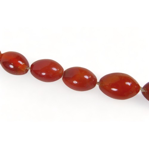 301 - An amber necklace with oval graduated beads, reddish amber colour, 80cms long plus 21 large amber be... 