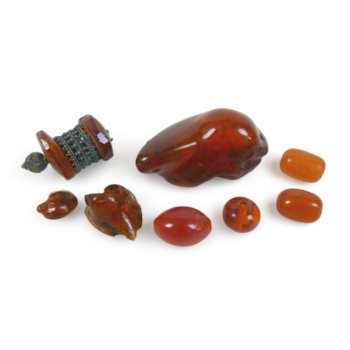 301 - An amber necklace with oval graduated beads, reddish amber colour, 80cms long plus 21 large amber be... 