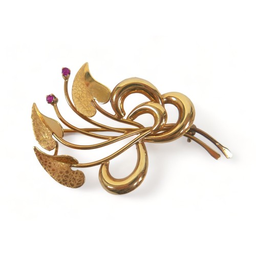 277 - An 18ct gold and ruby brooch, set with two rubies, shaped as three heart shaped textured leaves in a... 