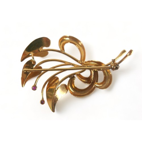 277 - An 18ct gold and ruby brooch, set with two rubies, shaped as three heart shaped textured leaves in a... 