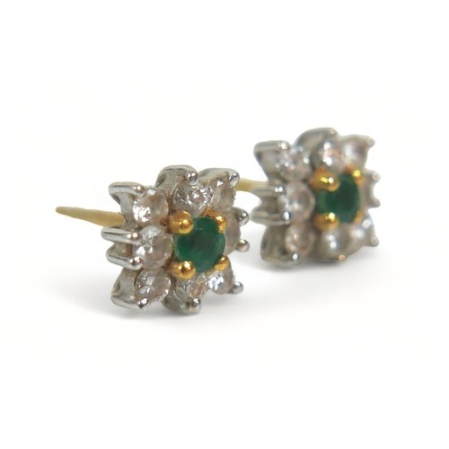 288 - A pair of diamond and emerald flowerhead earrings, each comprising eight brilliant cut diamonds arou... 