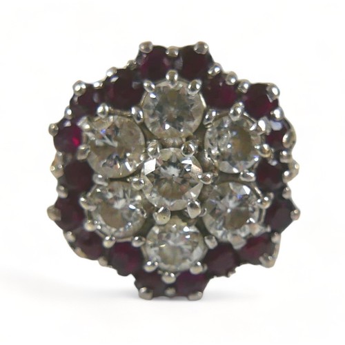 325 - An 18ct diamond and ruby cluster ring, with seven round cut diamonds to its centre, each stone appro... 