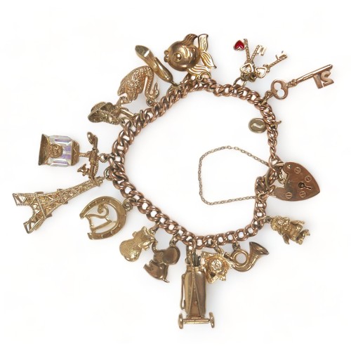 341 - A 9ct gold charm bracelet, fitted with heart shaped padlock clasp, kerb links, and sixteen charms, i... 