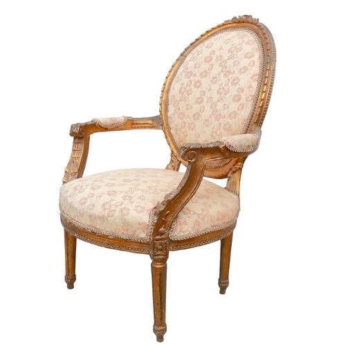 654 - A Louis XVI style open armchair, fauteuille a medallion, 20th century, carved and gilded frame, with... 